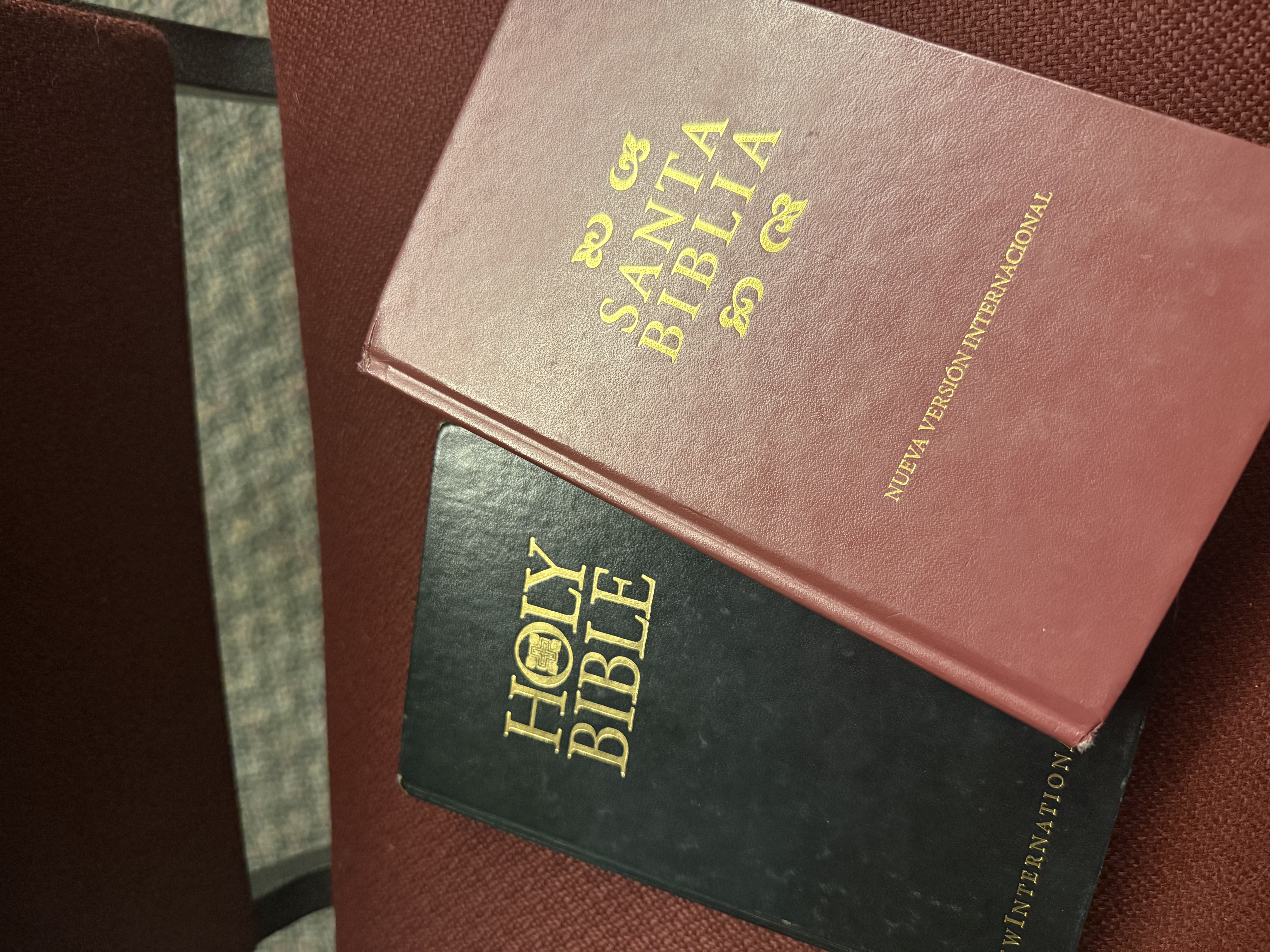 A English and Spanish Bible together on a chair.
